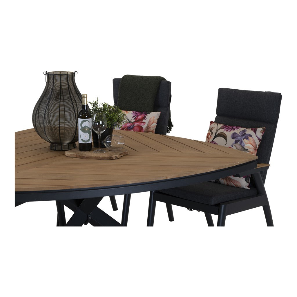 Driehoekige houten tafel met zwarte onderstel en donkergrijze stoelen met bloemenkussens