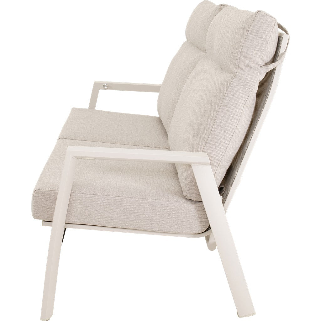 Loungebank in crème met schuine zithouding en dikke arm- en rugkussens, wit frame