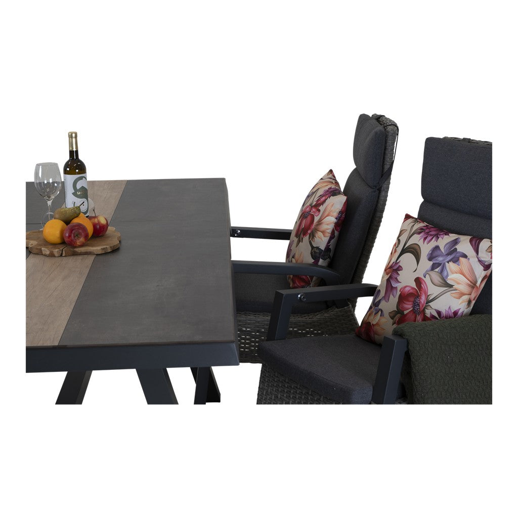 Uittrektafel met donker tafelblad en beige baan, geplaatst tussen stoelen met kussens.