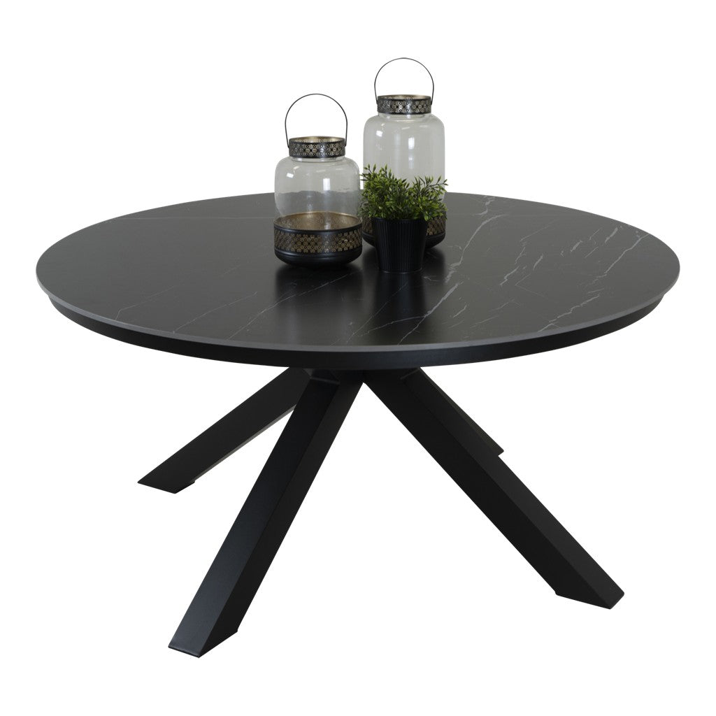 Ronde eettafel met donker blad en zwarte driepoot, met glazen flessen erop