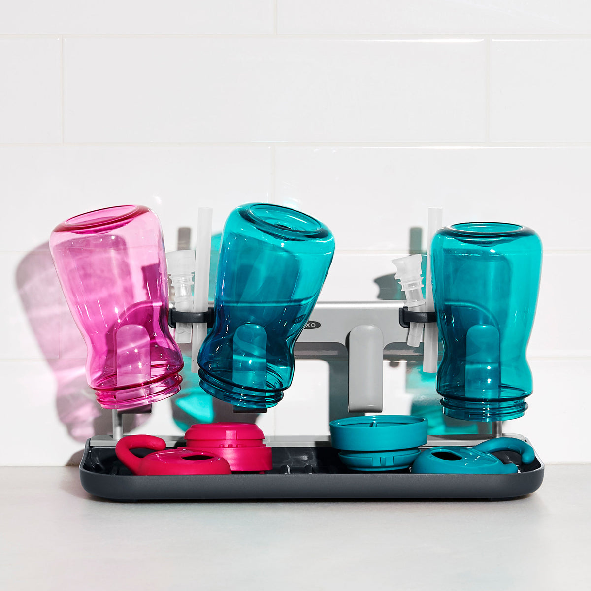 Droogrek met meerdere waterflessen; zwarte basis met roze en blauwe flessen en randen