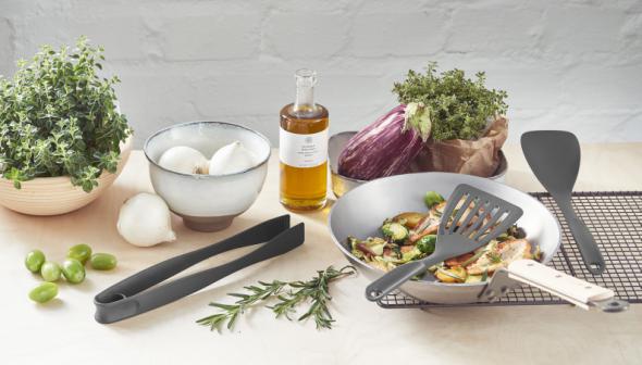 GastroMax spatel met sleuven, grijs, schept groenten uit een kom.