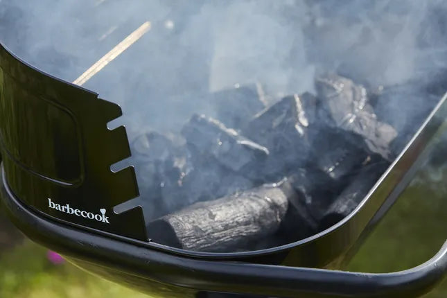 Zwarte Barbecook-deksel met luchtopeningen en grillrooster boven het vuur
