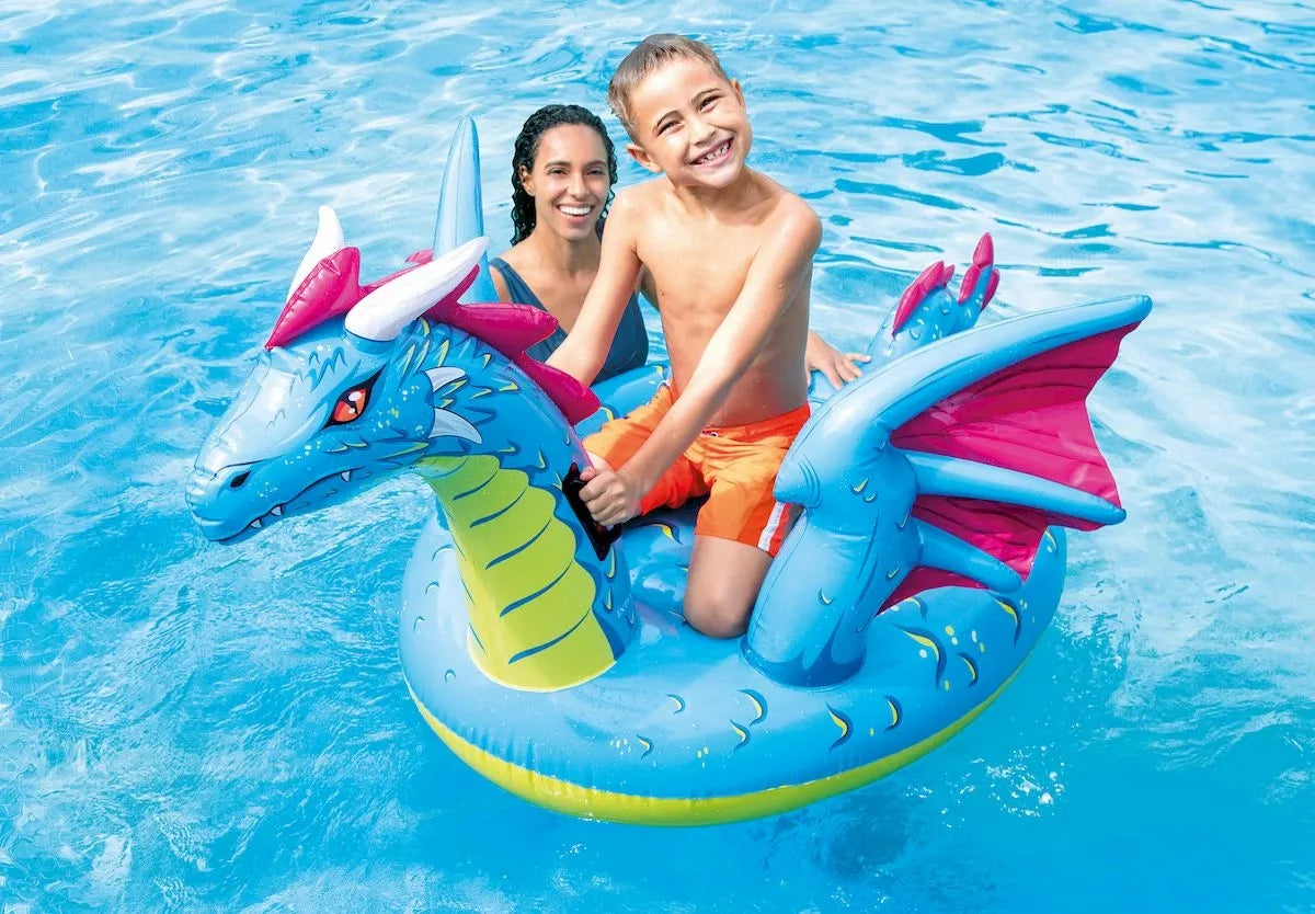 Opblaasbare drakenluchtbed in zwembad met kinderen erop; blauwe draak en roze vinnen