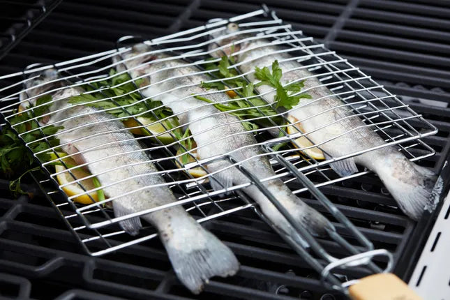 Visgrill met chroom rooster op bbq met drie vissen en groente