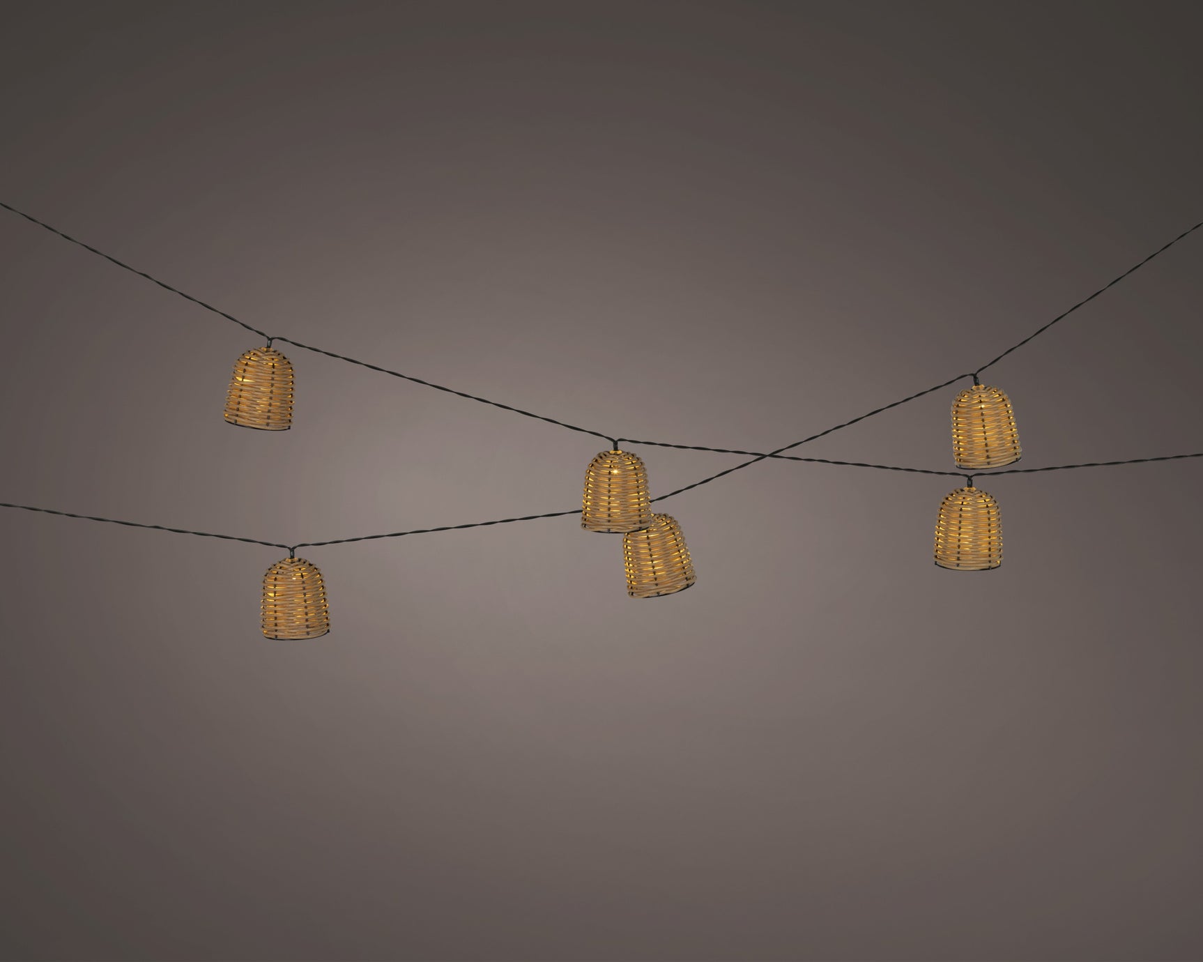 Slinger rieten lantaarns met warmgele gloed, op zonne-energie