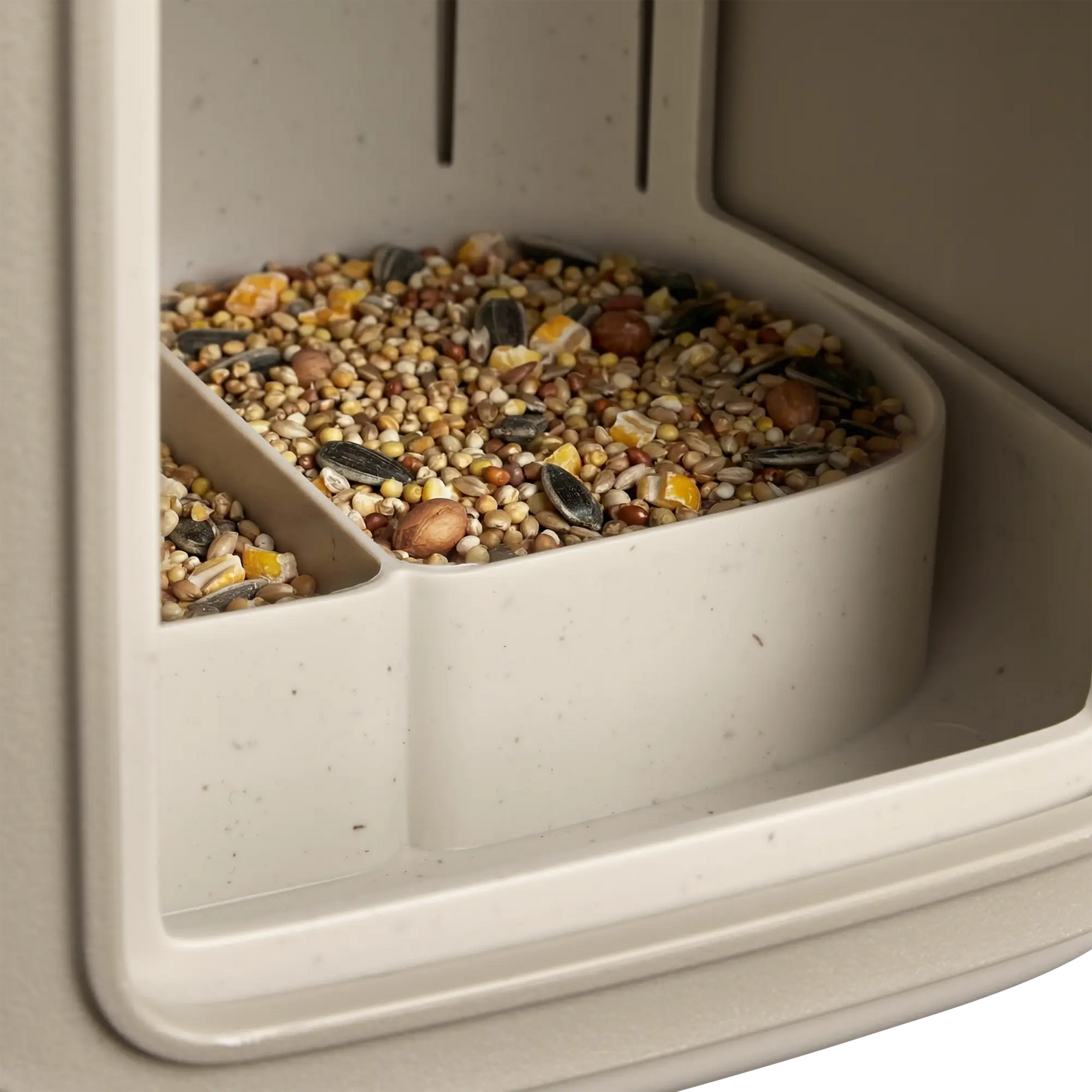 Open beige vogelvoerhuisje met zichtbaar vogelvoer in de voerbak