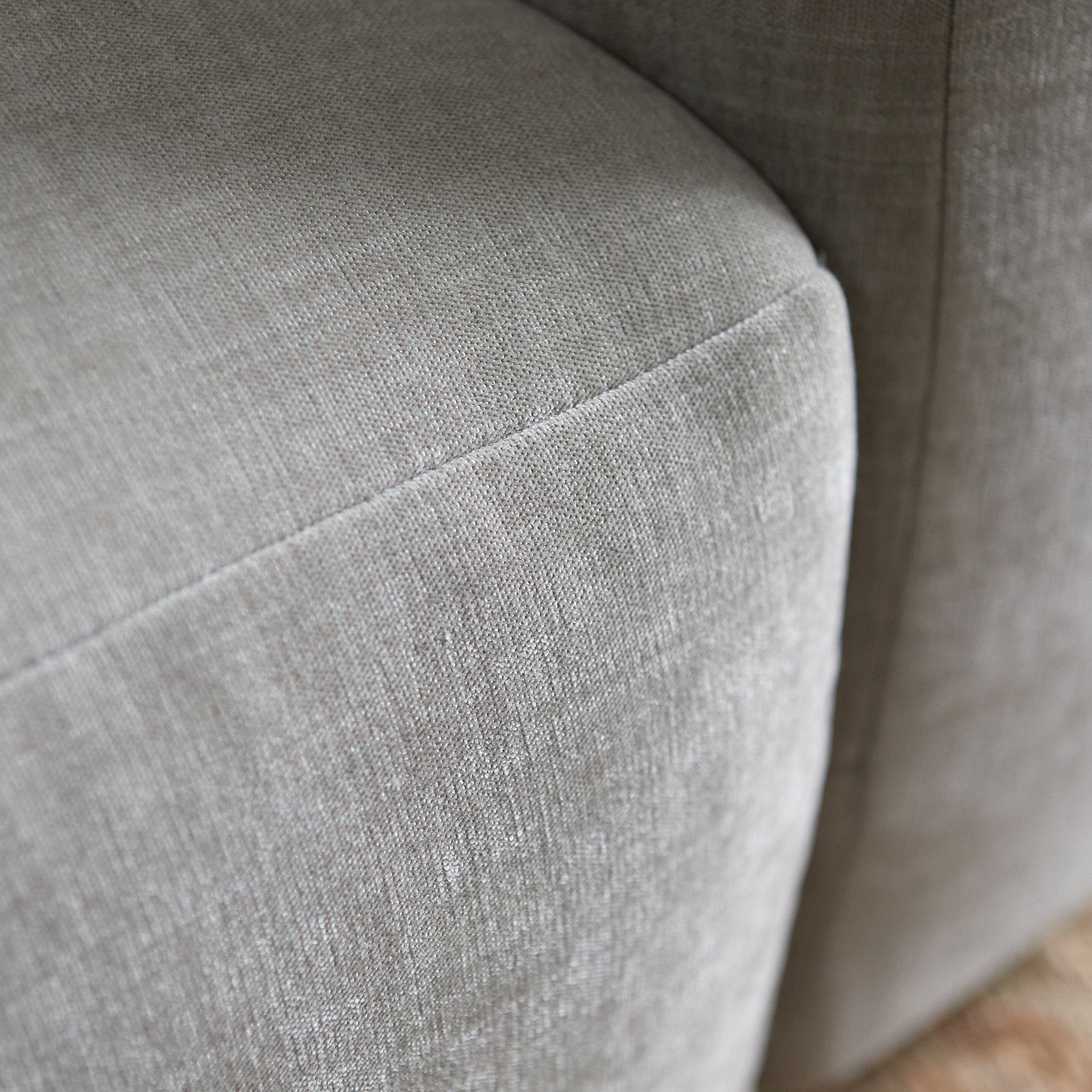 Rechts opgestelde grijze bank met chaise: close-up van gestoffeerde arm en zitting
