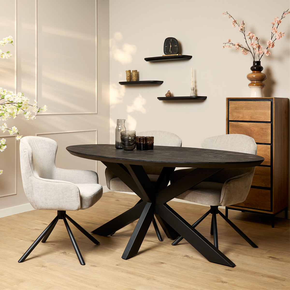Zwarte ovale eettafel met donker blad en X-vormig zwart metalen onderstel