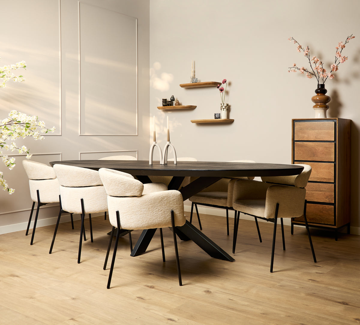 Ovale eettafel met zwarte blad en schuin kruisframe, in combinatie met witte stoelen