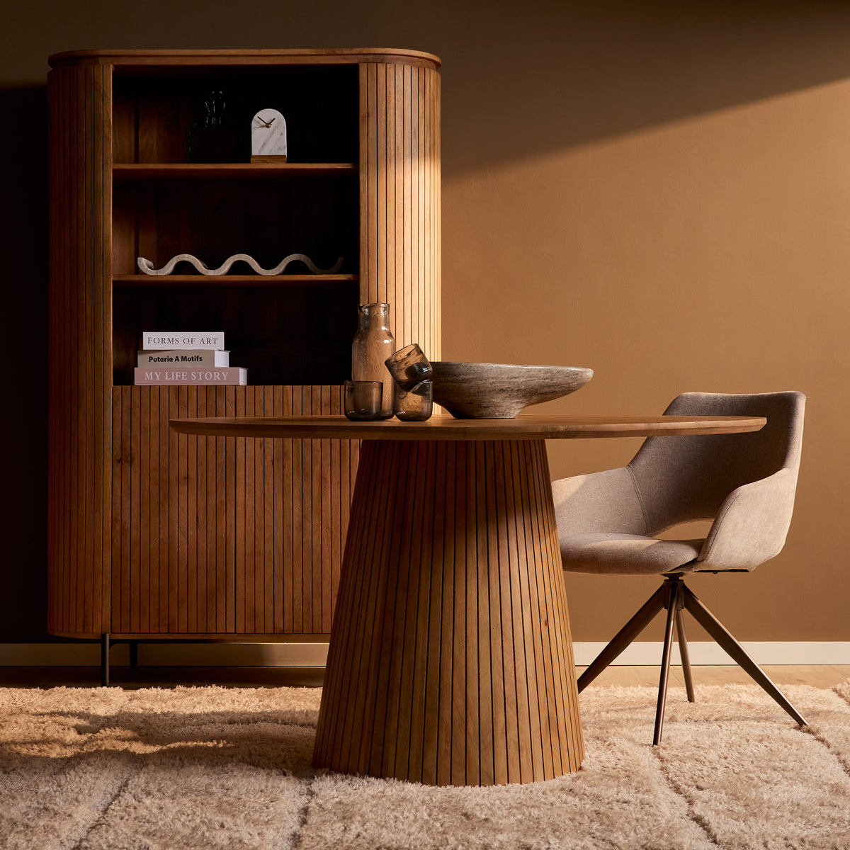 Ronde eettafel met naturel tafelblad en conische houten poot, stoelen naast tafel