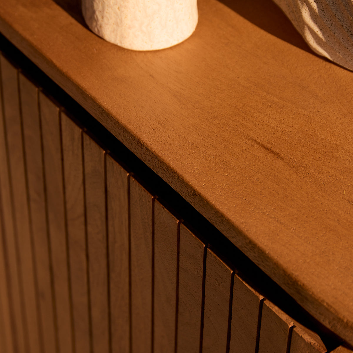 Naturel houten kast met ronde bovenbladrand en verticale latten.