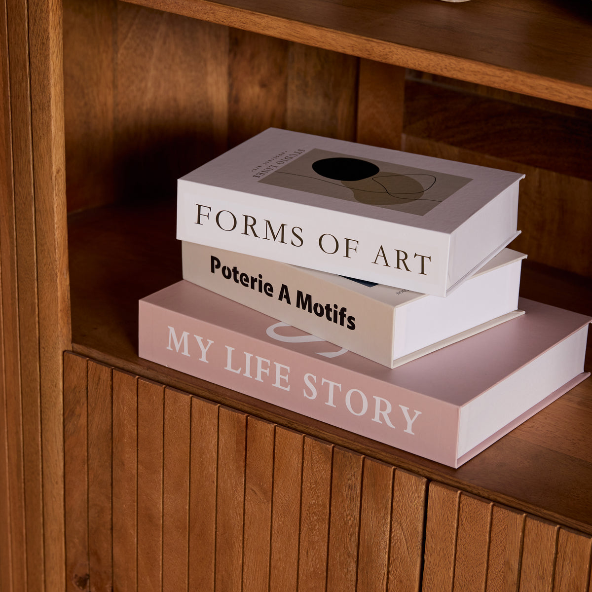 Houten kastplank met decoratieve boeken en opschriften, in naturel interieur.