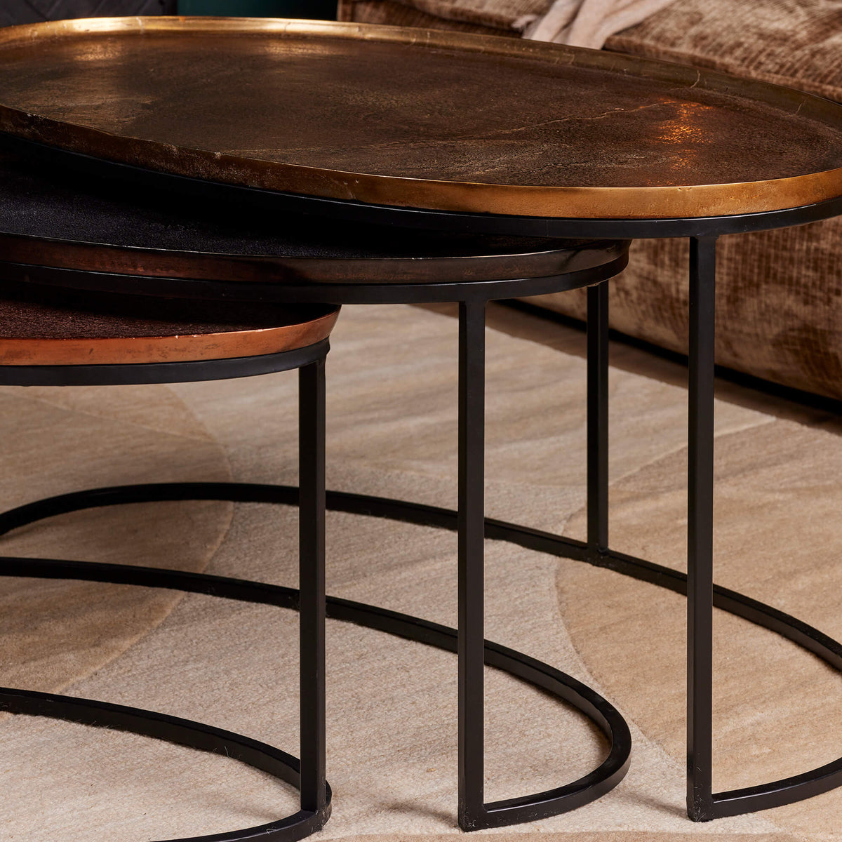 Ronde salontafels met bruin bladen en zwart metalen poten, genest