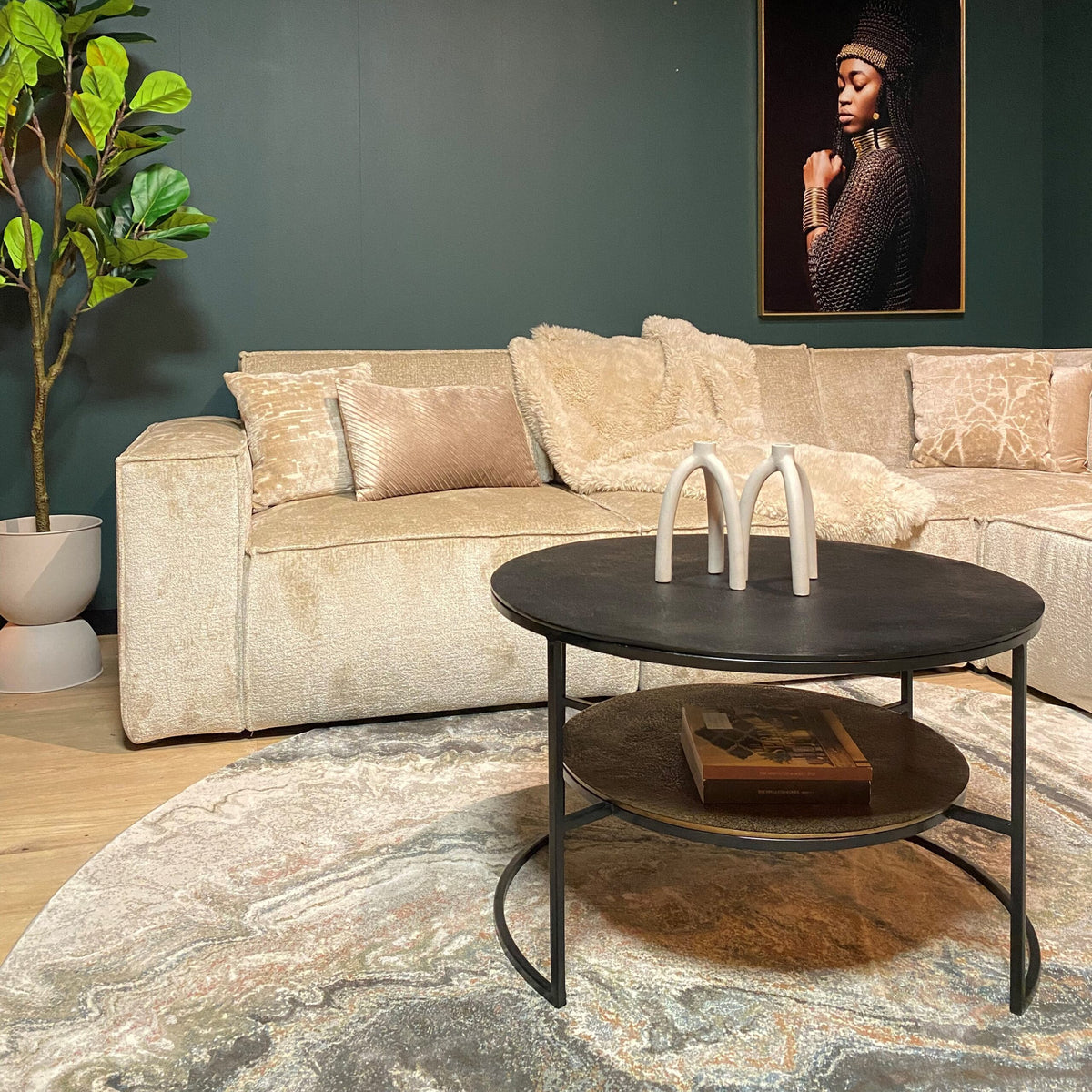 Zwarte ronde salontafel met open metalen frame en drie witte beugels op tafelblad
