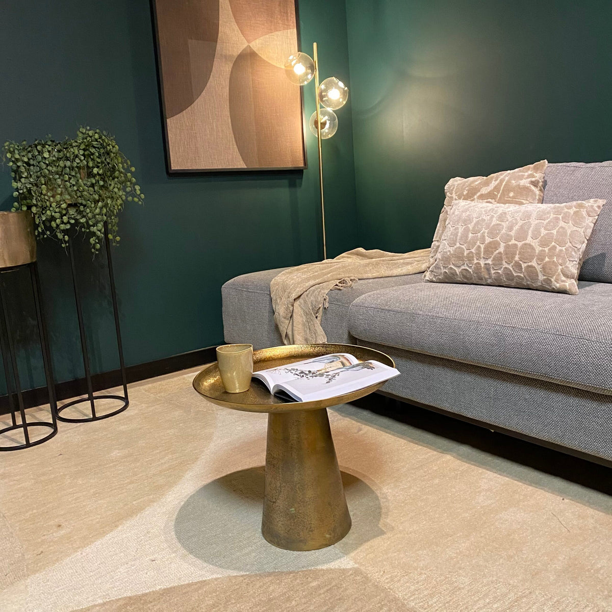 Ronde salontafel met goudkleurige afwerking en sierlijke poot, met tijdschrift