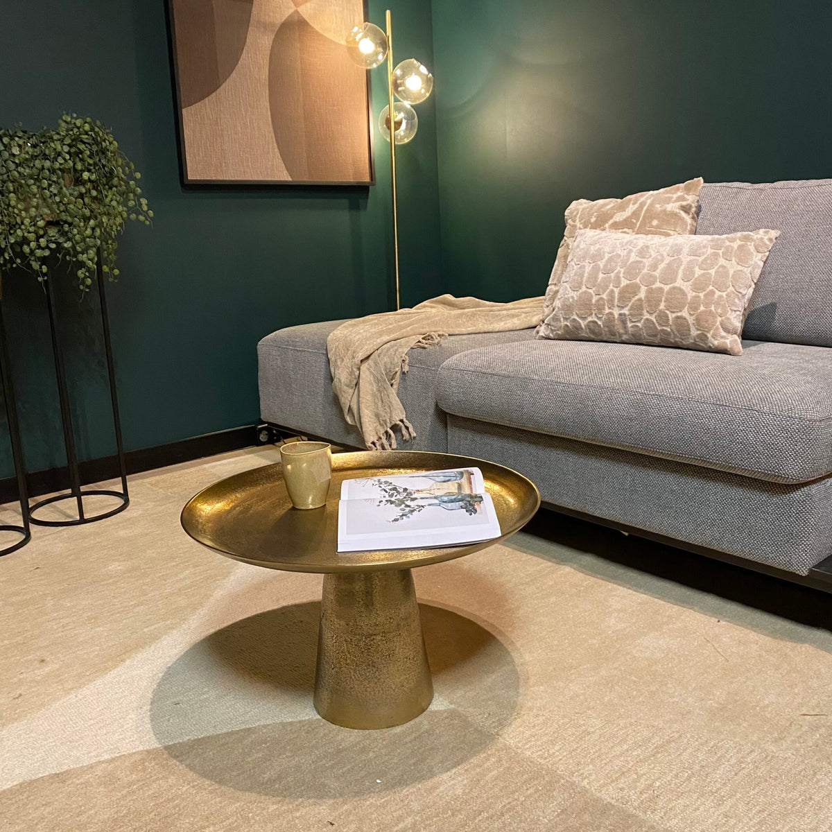 Gouden ronde salontafelset met middelste blad, tijdschrift en mok op het oppervlak