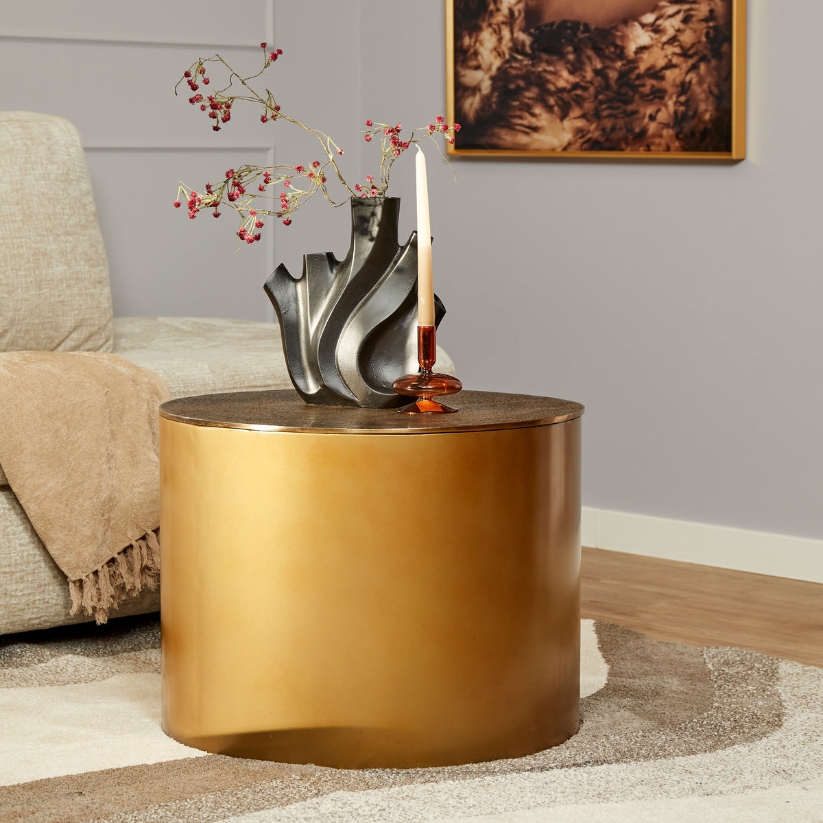 Gouden ronde salontafel Fiore met vlakke bladtop en cilindrische basis; zwarte decor.
