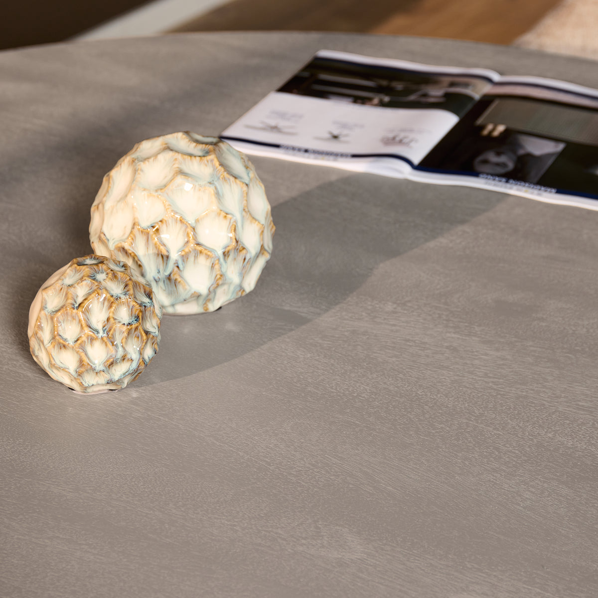 Taupekleurig tafelblad met twee decoratieve natuurstenen en tijdschrift