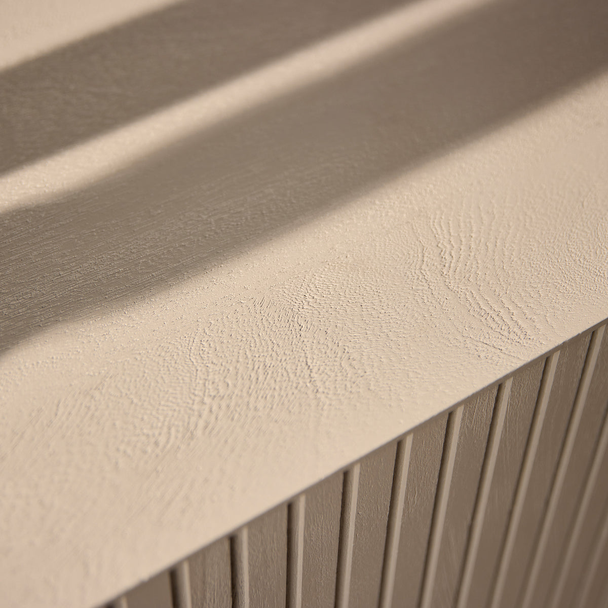 Zandkleurig dressoir: close-up van geribbelde fronttextuur