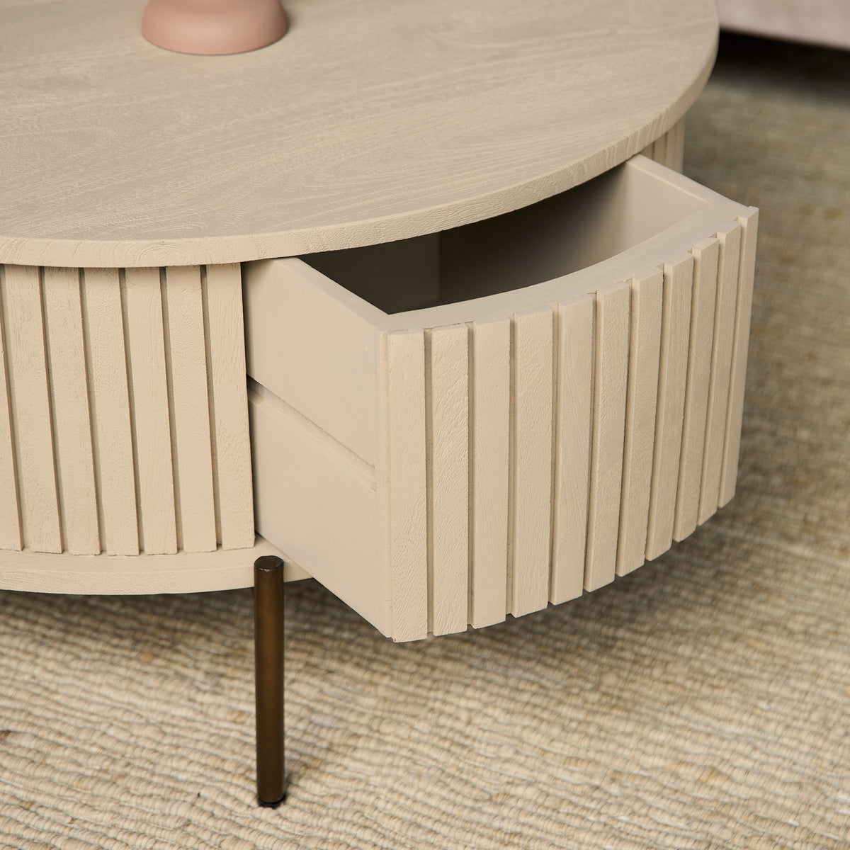 Ronde salontafel met open opbergruimte en verticale lamellen, zandkleurige afwerking