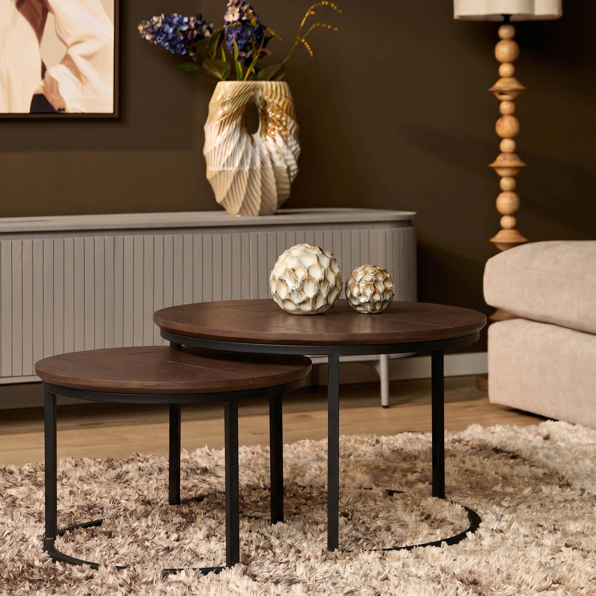 Set van 2 ronde salontafels met donkere houten bladen en zwart metalen onderstel