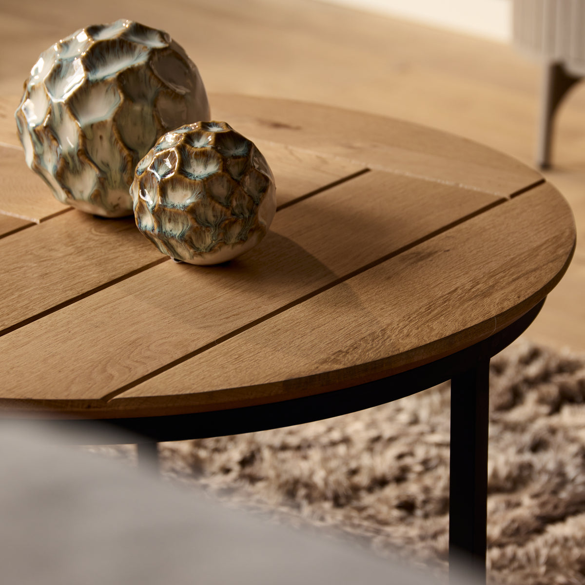 Ronde eiken salontafel met decoratieve poten en houtnerf op het tafelblad