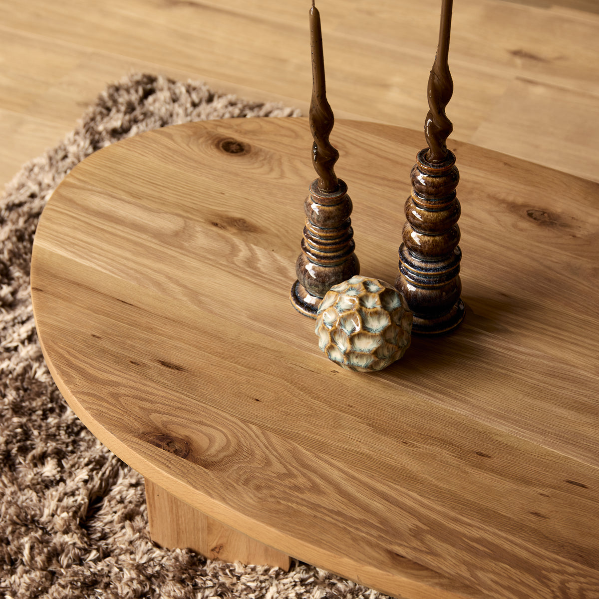 Ronde salontafel van naturel eiken met dikke poten en houtnerf op het blad