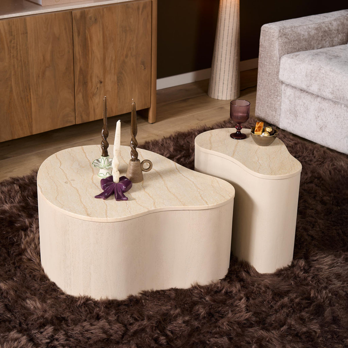 Twee salontafels met rond blad, licht zandkleurig, met marmerlook, afgeronde vormen