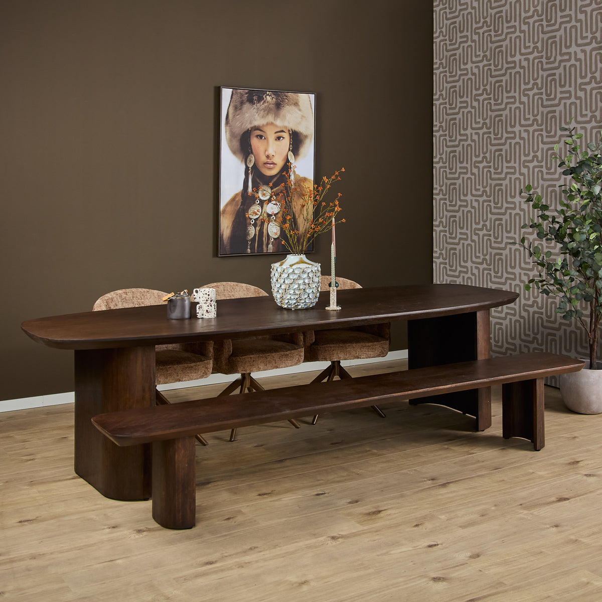 Eettafel van bruin hout met lang blad en open onderstel met dikke, lage poten