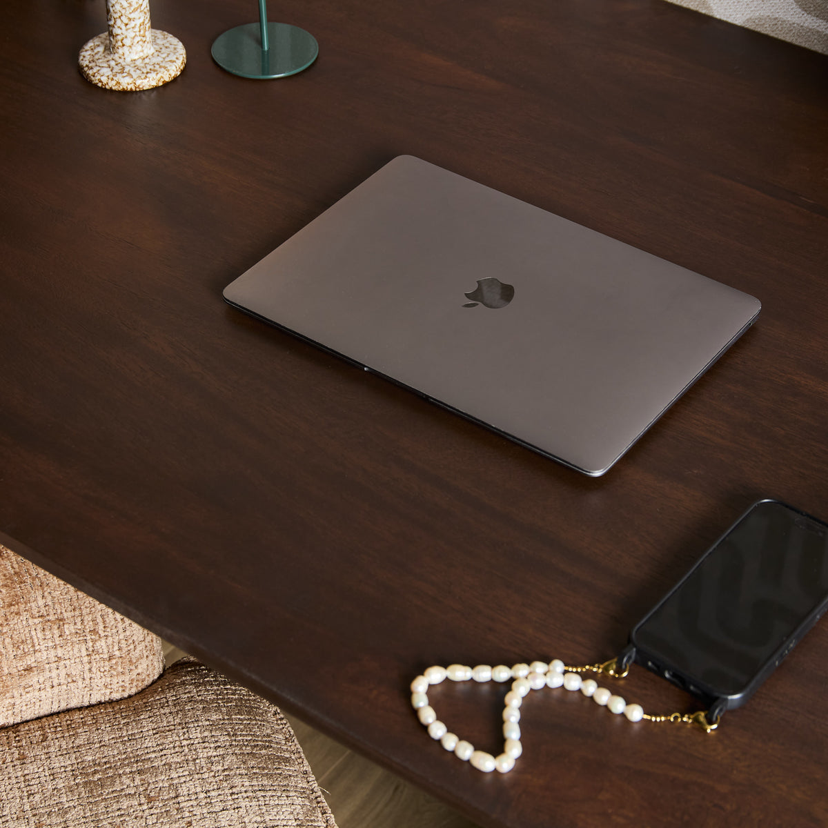 Bruin houten bureau met laptop op het blad en telefoon naast de rand