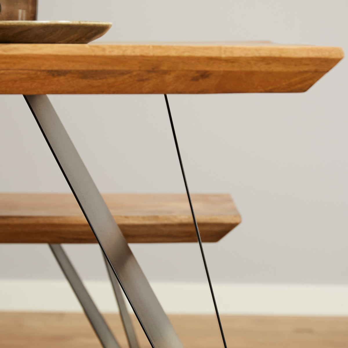 Detail: houten tafelblad op zwarte metalen poot