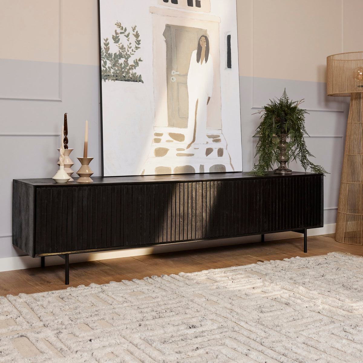 Zwart tv-meubel met verticale ribbels en lange opbergruimte, staand op smalle poten.