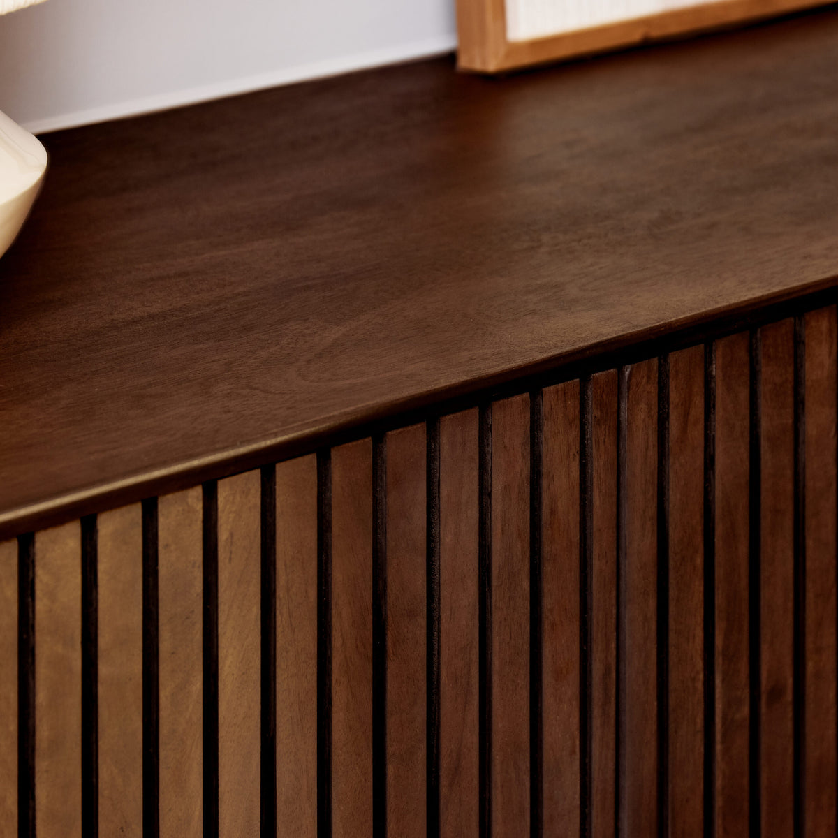 Bruin dressoir met geribbelde ladefronten en houten bovenblad, close-up