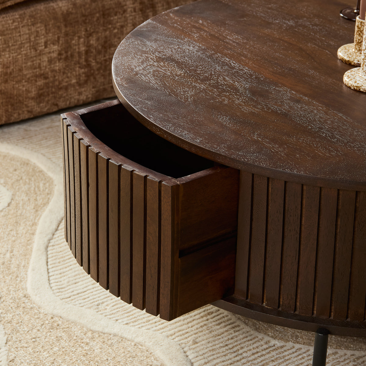 Detail van ronde salontafel: open lade onder het ronde houten blad met lamellenfront