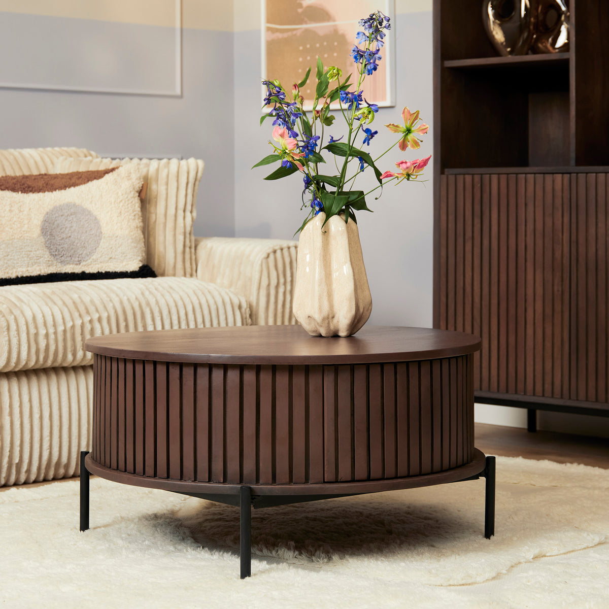 Ronde salontafel van donkerbruin hout met lamellen, rond blad en slanke poten