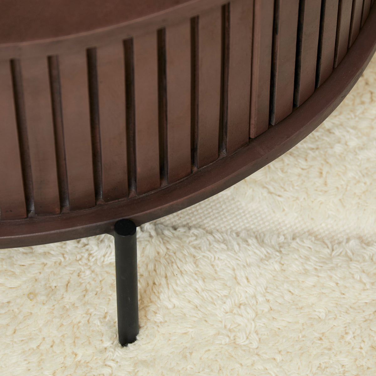 Ronde bruine houten salontafel met lattenrand en zwarte poot
