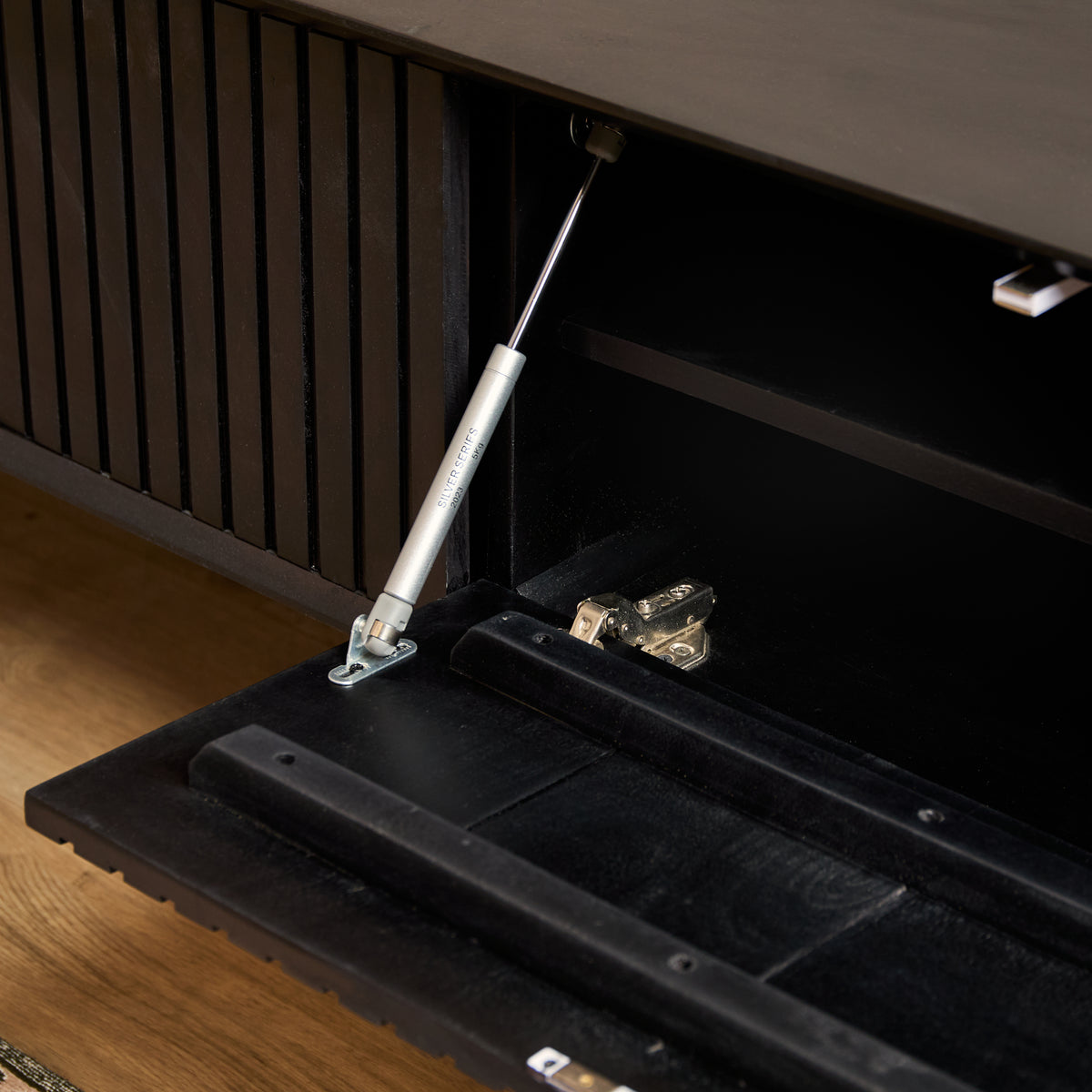 Zwart zwevend tv-meubel met open kabelruimte en opbergplanken onder het blad