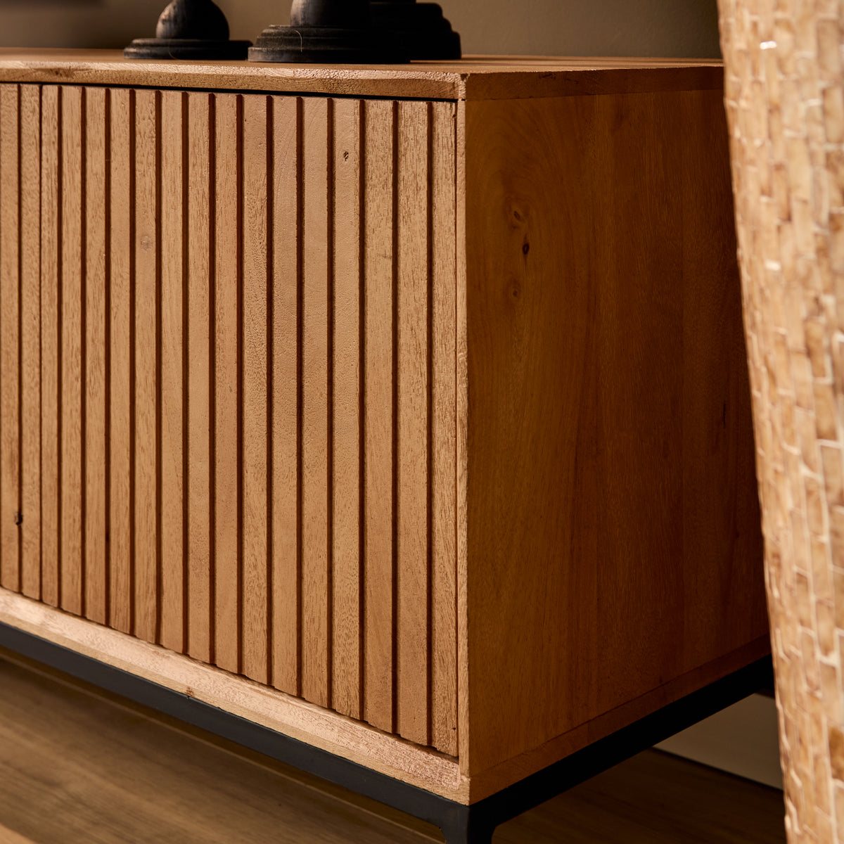 Tv-meubel in naturel hout met verticale latten en zwarte metalen onderrand
