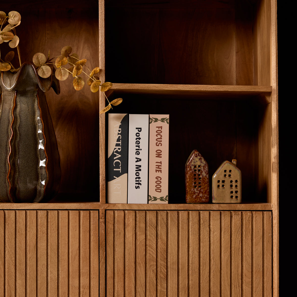 Vakkenkast met open vakken en planken; decor en boeken zichtbaar in het midden.