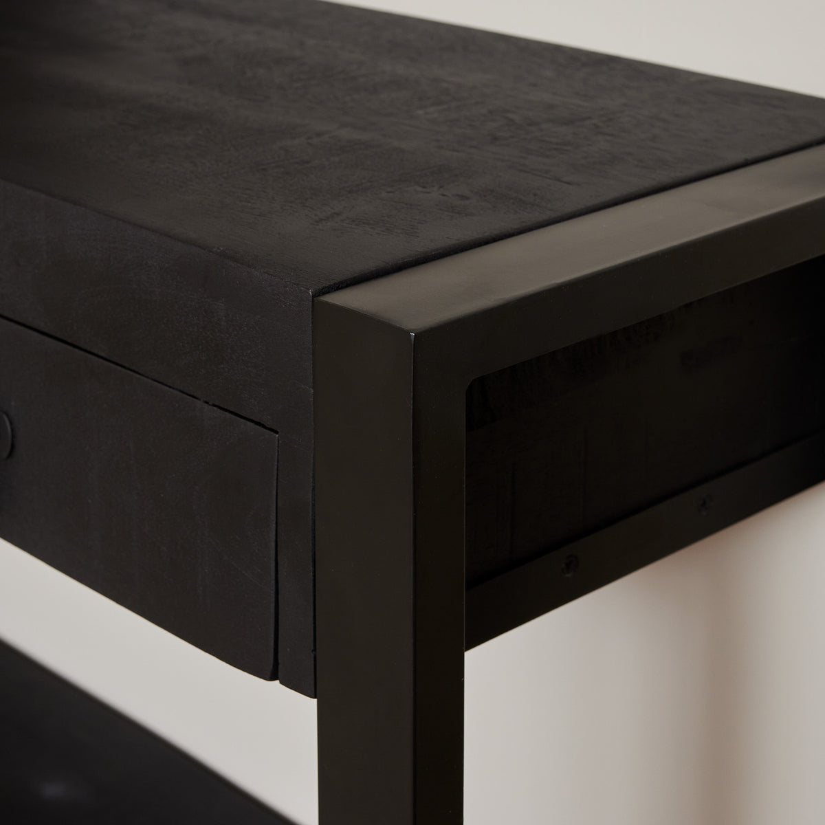Zwarte sidetable met hoekdetail, houtnerf op het bovenblad en ladefronten