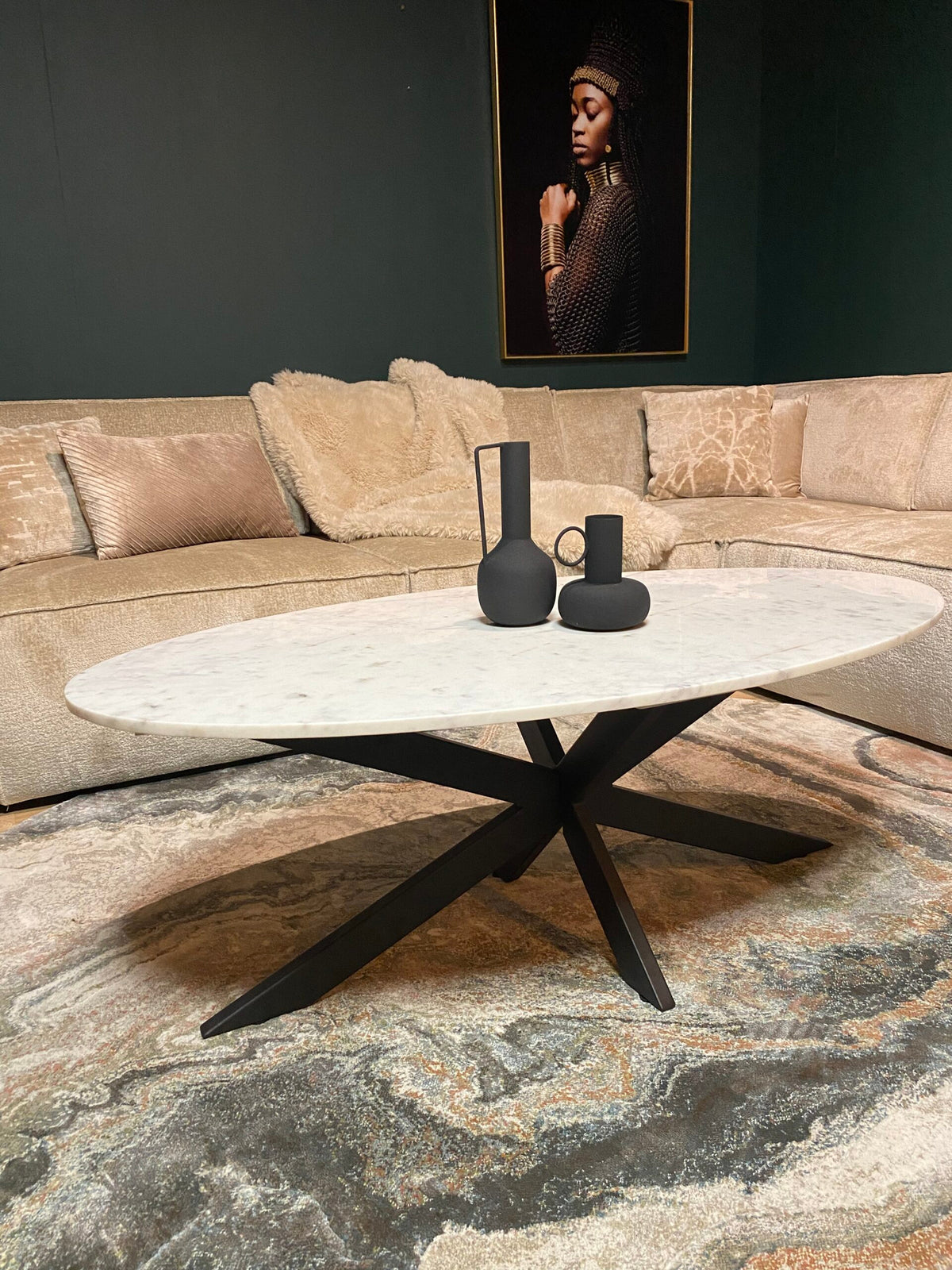 Ovale marmeren salontafel met wit blad, zwarte pootconstructie in kruisvorm