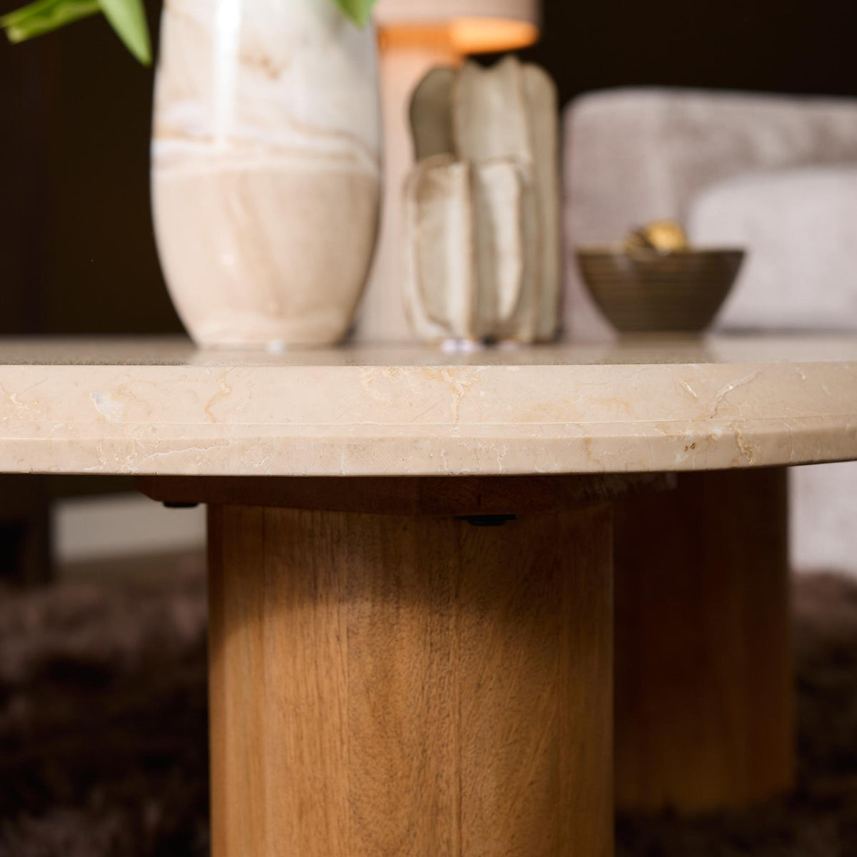 Ronde bijzettafel met licht marmeren blad en houten onderstel, close-up van de rand