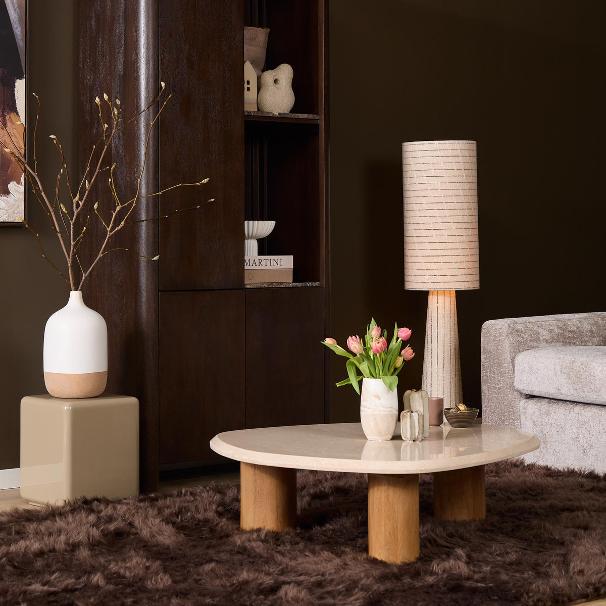 Ronde salontafel met licht marmerlook blad en brede houten poten.
