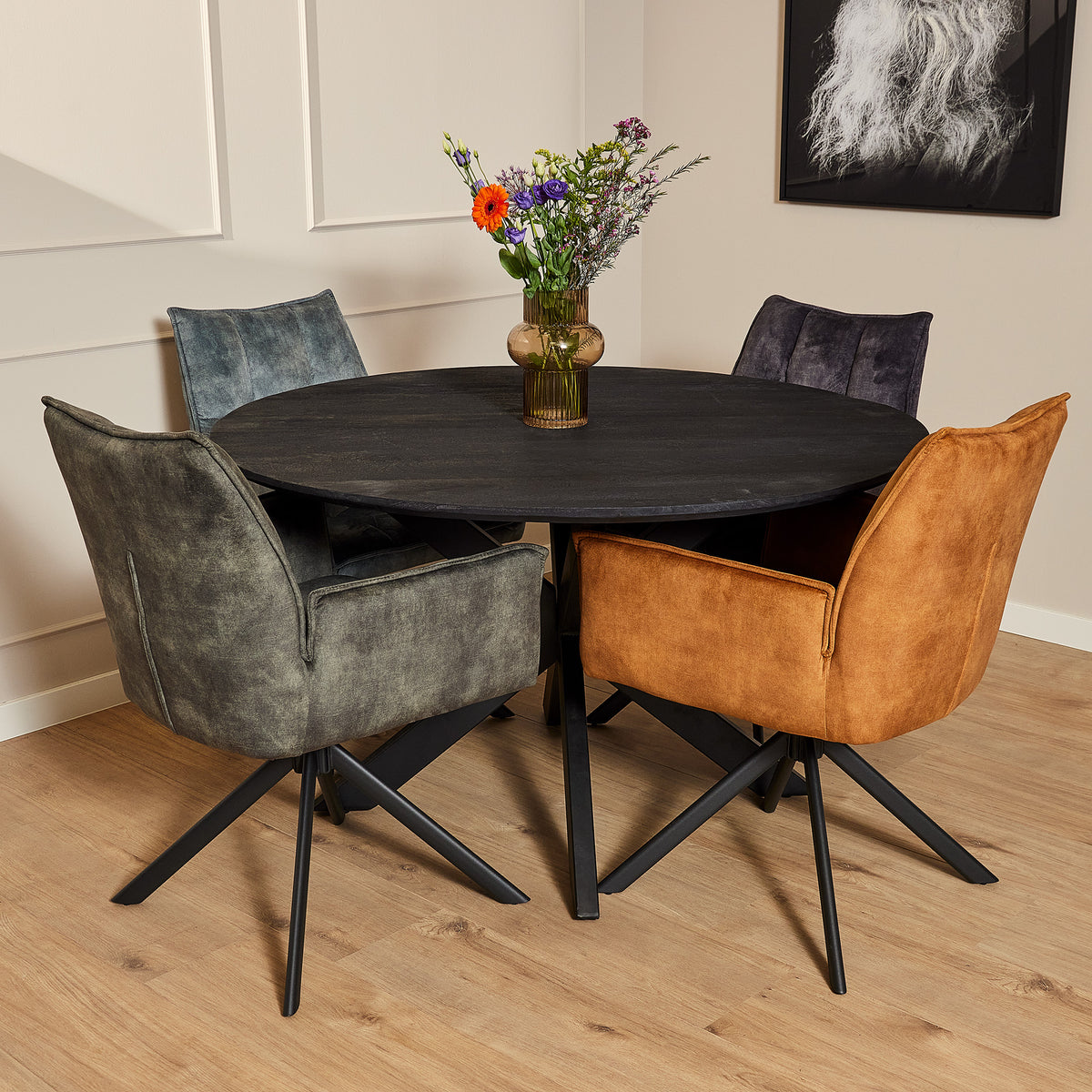 Draaibare eetkamerstoel met lichtblauwe fluwelen bekleding, naast oranje stoel aan tafel