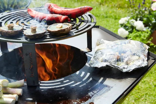 Barbecook verhoogd rooster op centre stand met open vuur en ronde grillring