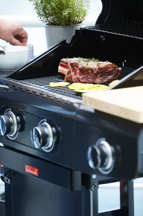 Grafiet barbecue met bedieningsknoppen en biefstuk op het kookrooster