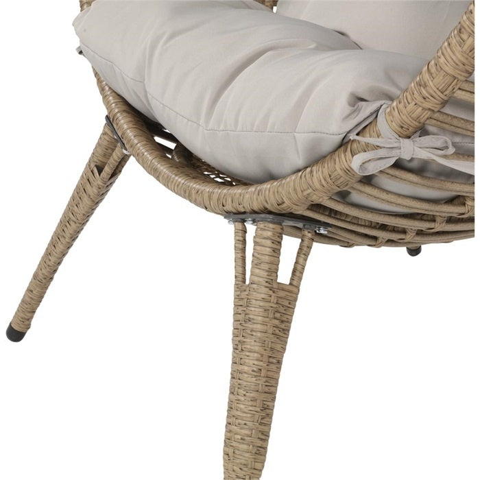 Rotan stoelpoten en grijze kussenhoes aan de zijkant van de stoel