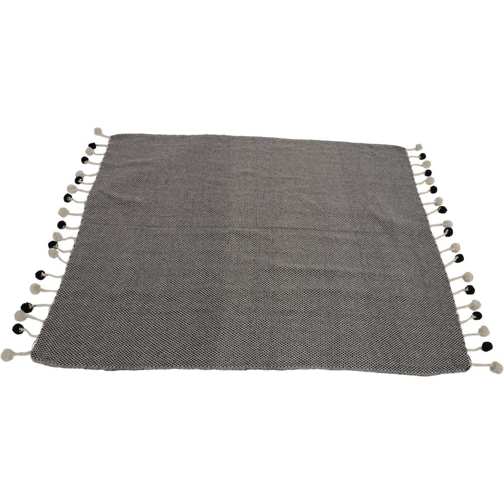 Gevouwen grijze plaid met pompons langs beide randen