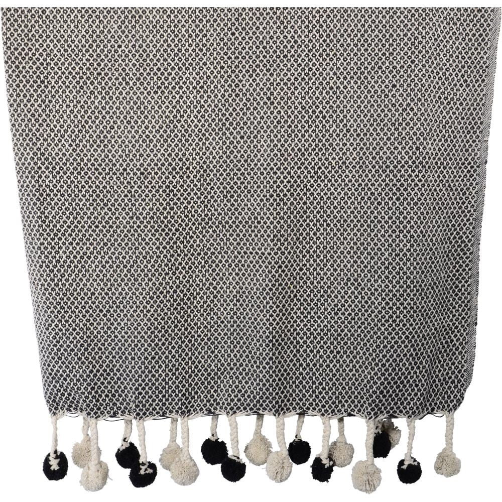 Ruitdeken zwart-wit met franje en zwarte/crèmekleurige pompons langs de rand